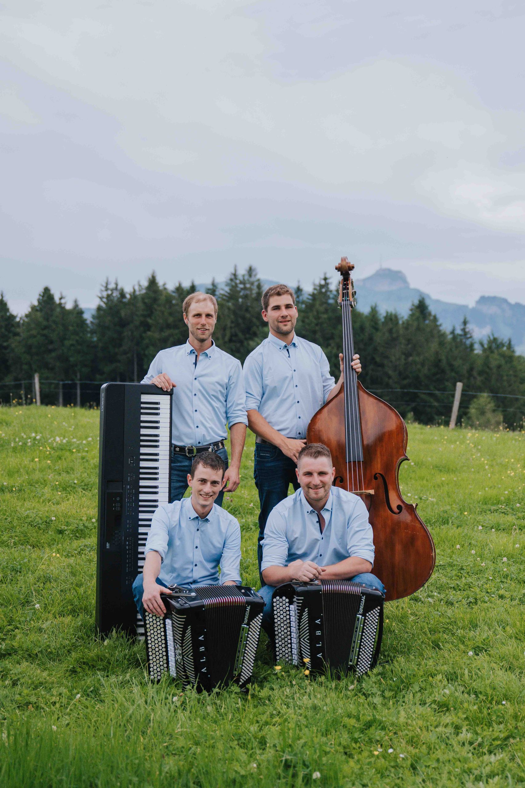 HD_Gaehler-Mueller_5 Handorgelduo Gähler-Müller mit ihren Instrumenten auf der Wiese im Hintergrund der Hohe Kasten